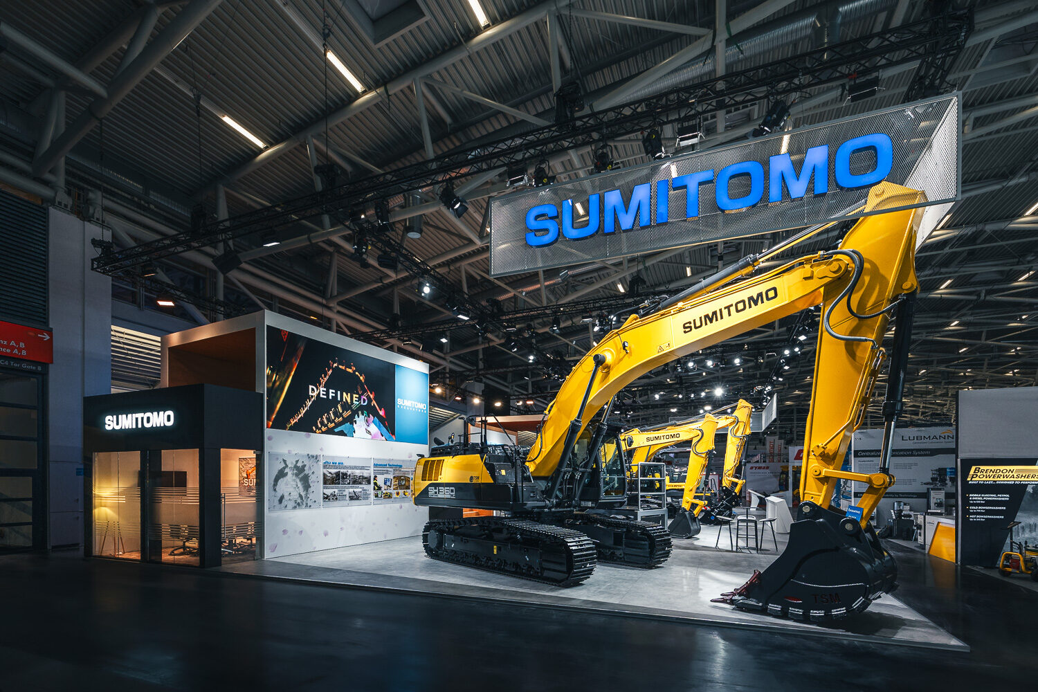 SUMITOMO-Messeauftritt auf der bauma mit Baggern und großem Markenschild
