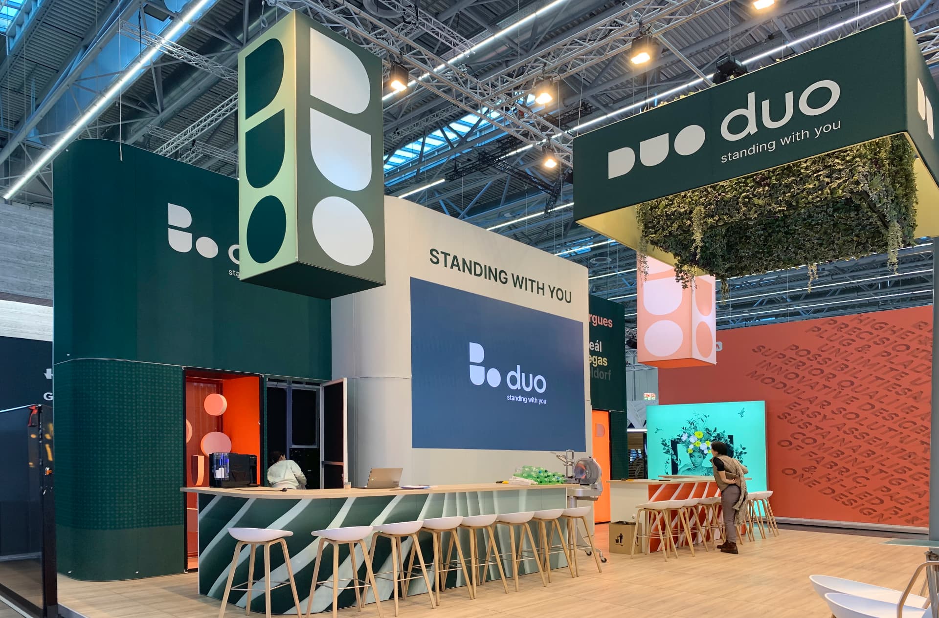 DUO-Messeauftritt mit Empfangstheke und hängenden Markenwürfeln